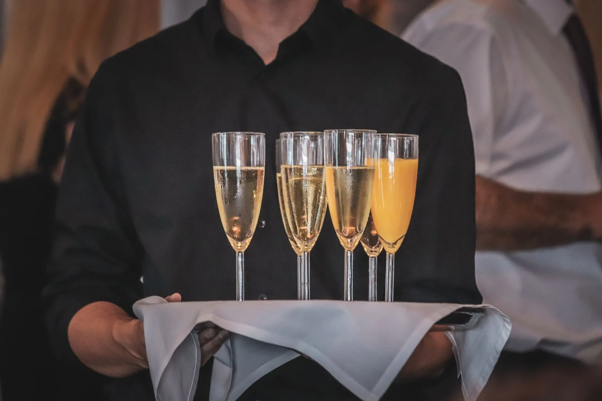 Tjener bærer en bakke med champagneglas til et event
